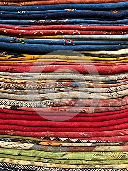 Closeup pile of colourful handwoven cloths, on sale Essaouira, Morocco