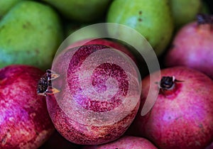 Closeup of a pile of pomegranate, pears in defokus back. Health