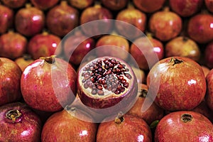 Closeup of pile pomegranates on market counter. Agricultural background. Healthy lifestyle, diet eating, organic vitamin