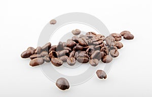 Closeup of a pile of roasted coffee beans isolated on a white background