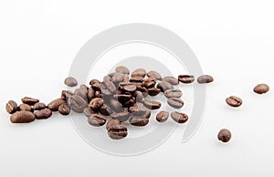 Closeup of a pile of roasted coffee beans isolated on a white background