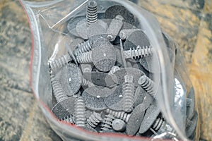 Closeup of a pile of screws in a plastic bag.