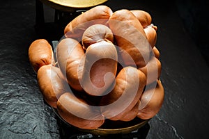 Closeup pile of short thick wieners rolled in spiral on scales