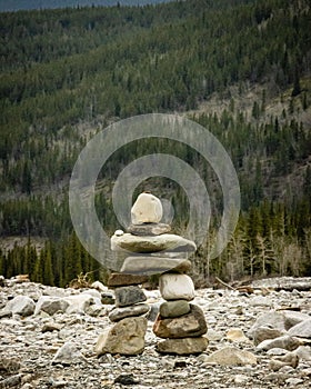 Closeup of pile of stones on a rocky road near a fir forest