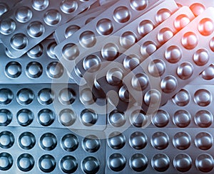 Closeup pile of tablets pills in silver blister pack. Pharmaceutical industry concept. Global healthcare. Health budgets.