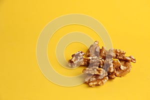 Closeup of a pile of walnuts under the lights isolated on a yellow background
