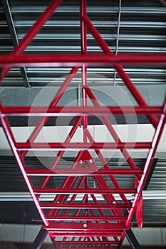 Closeup of pink horizontal bars for a workout, cylindrical crimson metal bars on a light silvery background.