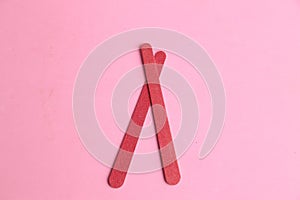 Closeup of a pink nail file on the same colored background photo
