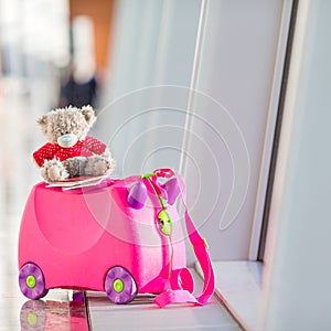 Closeup pink small kids suitcase in airport near