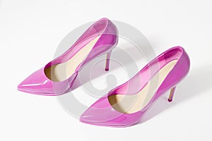 Closeup pink women patent leather shoes isolated on white background. Stilettos shoe type. Summer fashion and shopping concept.