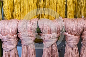 Closeup pink and yellow cotton thread thread background, textile industry concept