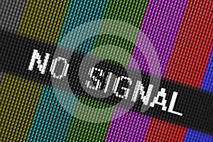 Closeup pixels of LCD TV screen with color bars and message no signal is a television test pattern