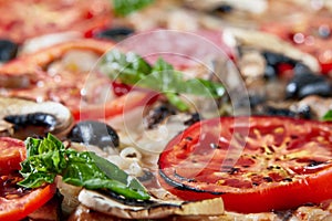 Closeup of pizza with salami, tomatoes and olives