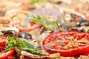 Closeup of pizza with salami, tomatoes and olives