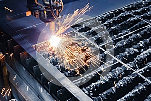 Closeup plasma cutting CNC machine cuts metal material with sparks. Concept industry background, blue color