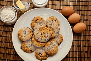 Closeup of a plate with chocolate chip cookies with ingredients.