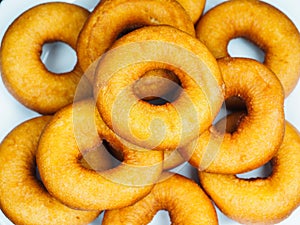 Closeup of a plate with freshly made brown doughnuts