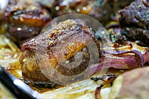 Closeup of a plate of grilled lamb chops with onions and potatoes