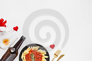 Closeup of a plate of pasta, wine bottle, and wine glass- concept Valentine\'s day