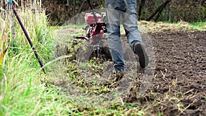 Closeup of plowing the land with motor cultivator. Agriculture