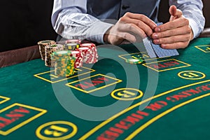 Closeup of poker player with playing cards and chips