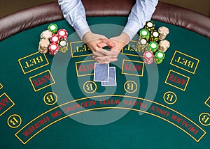 Closeup of poker player with playing cards and chips