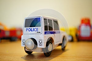 Closeup of a police car toy next to other toys on a blurry background