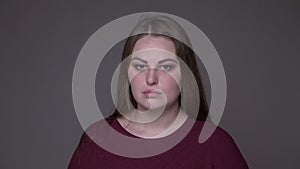 Closeup portarit of young sad overweight caucasian female being upset and depressed looking at camera with background