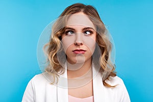 Closeup portrait of adorable funny woman looking cross-eyed with awkward silly dumb face. blue background
