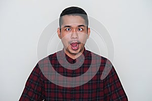 Closeup portrait of adult Asian man showing funny ugly face