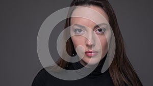 Closeup portrait of adult attractive caucasian female face looking at camera with background isolated on gray