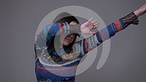 Closeup portrait of adult caucasian brunette female dabbing with confidence in front of the camera with background