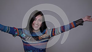 Closeup portrait of adult caucasian brunette female turning around with her hair fluttering smiling happily looking at