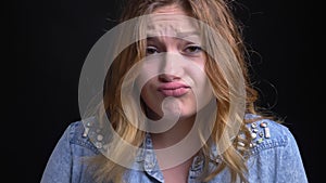 Closeup portrait of adult caucasian female being upset and disappointed making a cute childish facial expression in