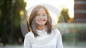 Closeup Portrait of Amazing Brunette Looking at the Camera and Laughing During Summer Sunset in the City. Pretty Woman