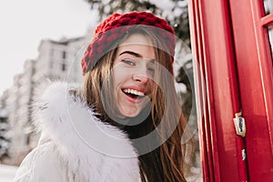 Closeup portrait amazing nice young woman with long brunette hair, in red hat, expressing positive emotions to camera on