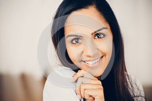 Closeup portrait of attractive indian young woman smiling at home