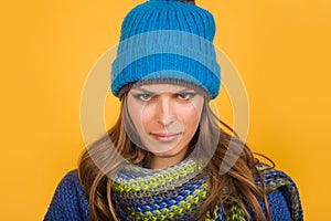 Closeup portrait of attractive young woman in warm sweater, hat and scarf. Autumn-winter clothing. Smiling girl in