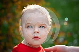 Closeup portrait of baby boy with big eyes. Serious little boy with intent look. face of small child