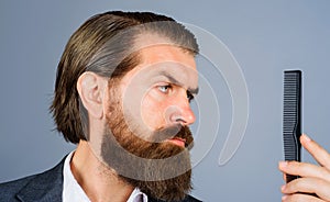 Closeup portrait of bearded man with comb. Barbershop. Barber or hairdresser with hair comb. Barber professional tools