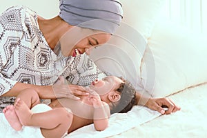 Closeup portrait of beautiful african woman holding on hands her little daughter on white background. Family, love, lifestyle,