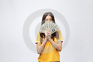 Closeup portrait of beautiful asian woman holding money isolated on white background. Asian girl counting her salary