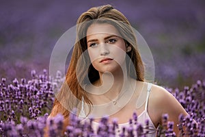 Closeup portrait of beautiful brunette girl posing in lavender field