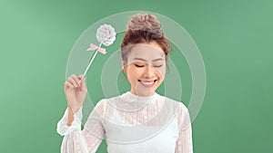 Closeup portrait of beautiful fashion cheerful woman eating sweet candy lolly pop over green background