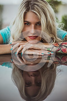 Closeup portrait of. Beautiful girl put her head in her arms with tattoos. expectation. photo