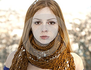 Closeup portrait of beautiful girl in snow-covered scarf