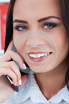Closeup portrait of a beautiful laughing girl talking on the mobile phone.