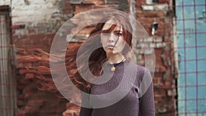 Closeup portrait of a beautiful red-haired girl. hair fluttering in the wind. girl with mysterious eyes. slow motion