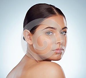 Closeup portrait of beautiful woman with smooth glowing face. Headshot of caucasian model isolated against a grey