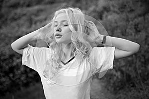 Closeup portrait of a beautiful young blonde woman in the park, the concept of beauty and health. Black and white photo.